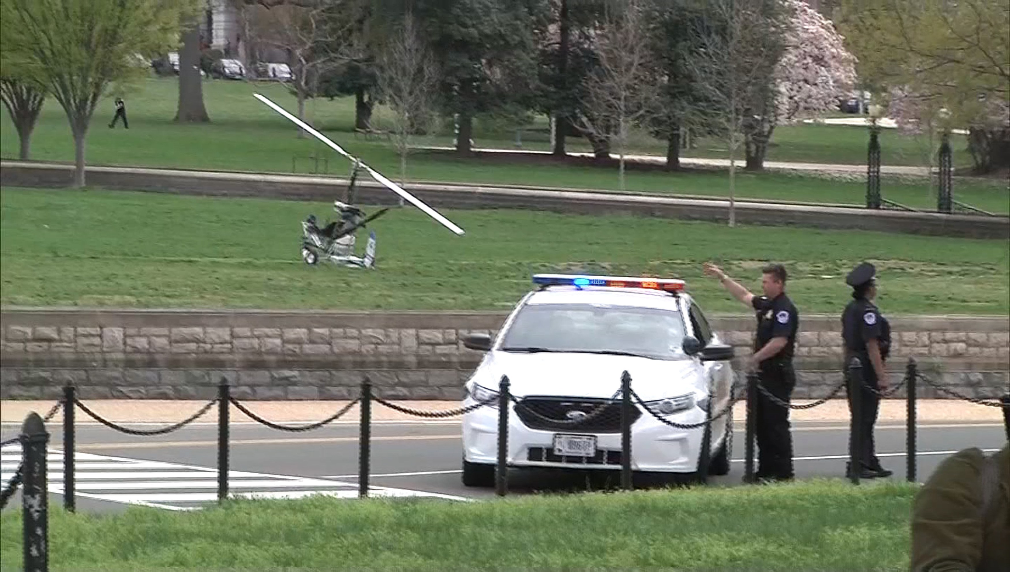 A small helicopter (L) is pictured in this still image taken from video after it landed on the west lawn of the U.S. Capitol in Washington April 15, 2015. One person was detained and nearby streets were temporarily closed as police investigated, according to a police statement that called the craft a "gyro copter." REUTERS/Courtesy of NBC4/WRC/Handout via Reuters ATTENTION EDITORS: FOR EDITORIAL USE ONLY. NOT FOR SALE FOR MARKETING OR ADVERTISING CAMPAIGNS. NO SALES NO ARCHIVES DC METRO OUT. THIS IMAGE HAS BEEN SUPPLIED BY A THIRD PARTY. IT IS DISTRIBUTED, EXACTLY AS RECEIVED BY REUTERS, AS A SERVICE TO CLIENTS